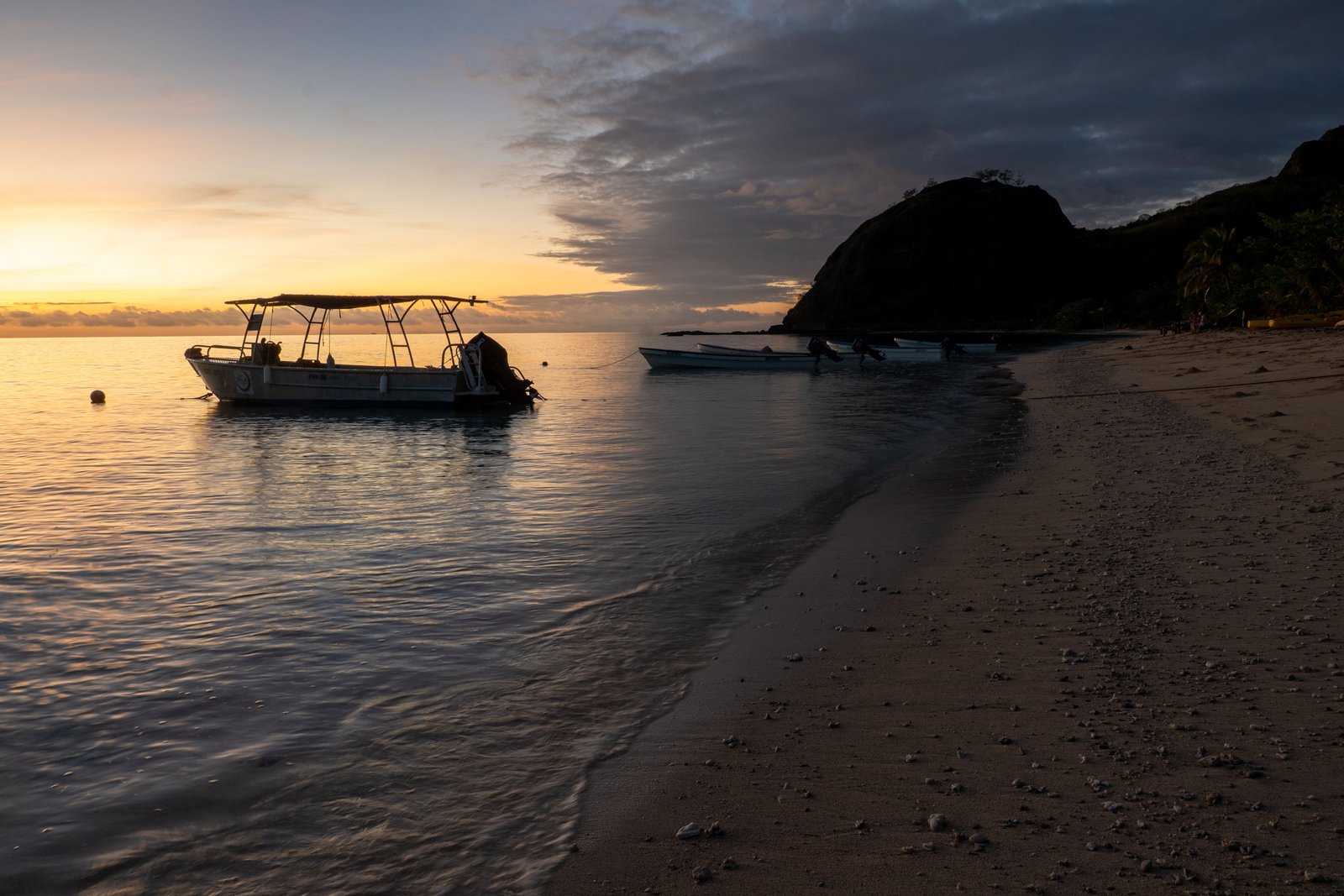 Boat at sunrise on a calm Fiji shoreline